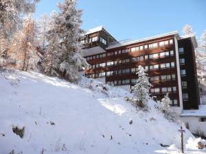 un edificio sobre una pendiente cubierta de nieve frente a un edificio en Appartement Vars, 2 pièces, 4 personnes - FR-1-330B-129 en Vars