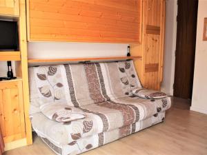 un divano in una stanza con televisore di Appartement Vars, 1 pièce, 2 personnes - FR-1-330B-131 a Vars