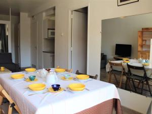 una mesa con tazones amarillos y platos en ella en Appartement Vars, 2 pièces, 6 personnes - FR-1-330B-98 en Vars