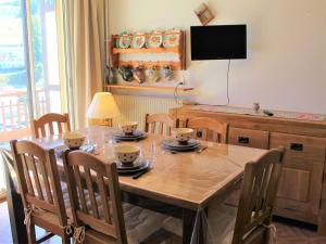 a dining room table with chairs and a television at Appartement Vars, 1 pièce, 4 personnes - FR-1-330B-134 in Vars