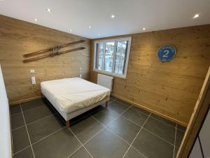 a bedroom with a bed in a wooden wall at Appartement Vars, 3 pièces, 8 personnes - FR-1-330B-146 in Vars
