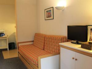 Habitación con sofá y escritorio con TV. en Appartement Vars, 1 pièce, 4 personnes - FR-1-330B-104 en Vars