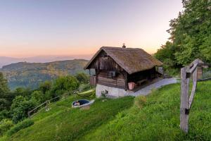 una casa vieja en una colina con una valla en Holiday home in Otocec - Kranjska Krain 26039, en Otočec