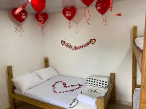 Cette chambre comprend un lit avec des cœurs et des ballons. dans l'établissement Finca Villa Maju, à Papagalleros 23 autres photos