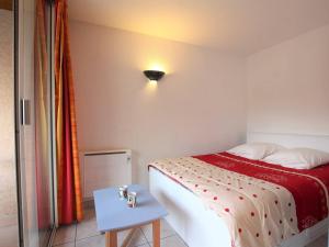 a small bedroom with a bed and a table at Appartement Briançon, 2 pièces, 4 personnes - FR-1-330C-5 in Briançon