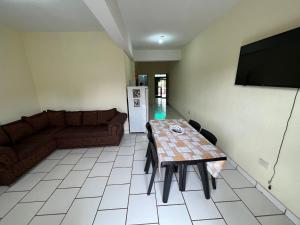 sala de estar con mesa y sofá en Malibu Apart en Puerto Iguazú