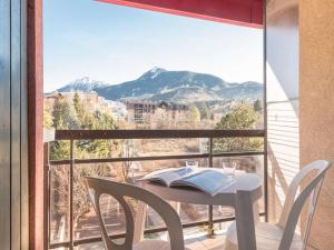 uma mesa e cadeiras numa varanda com vista em Appartement Briançon, 2 pièces, 4 personnes - FR-1-330C-5 em Briançon