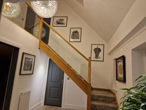 a staircase in a house with pictures on the wall at Hillvine in Hartpury