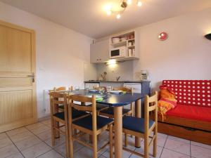 una cucina e una sala da pranzo con tavolo e sedie di Appartement Briançon, 2 pièces, 4 personnes - FR-1-330C-5 a Briançon