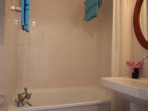 een badkamer met een bad, een wastafel en een bad bij Appartement Puy-Saint-Vincent, 1 pièce, 4 personnes - FR-1-330G-51 in Puy-Saint-Vincent