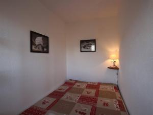 een slaapkamer met een bed en twee foto's aan de muur bij Appartement Puy-Saint-Vincent, 1 pièce, 4 personnes - FR-1-330G-51 in Puy-Saint-Vincent