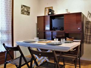 a dining room table with chairs and a tv at Appartement Risoul, 1 pièce, 4 personnes - FR-1-330-498 in Risoul