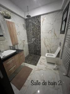 uma casa de banho com um chuveiro, um lavatório e um WC. em Villa Dar lynoute piscine sans vis à vis plage à pieds em Taguermess