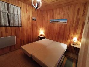 um quarto com uma cama branca numa parede de madeira em Appartement Saint-Michel-de-Chaillol, 2 pièces, 4 personnes - FR-1-393-146 em Saint-Michel-de-Chaillol