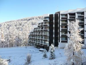 un immeuble dans la neige avec des arbres enneigés dans l'établissement Appartement Vars, 1 pièce, 4 personnes - FR-1-330B-85, à Vars