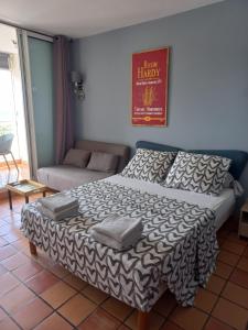 a bedroom with a bed and a couch in a room at Studio La "KAZ À COCO" Tartane in La Trinité +9 photos