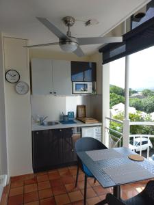 a kitchen with a table and a counter top at Studio La "KAZ À COCO" Tartane in La Trinité