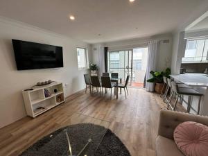 - un salon avec un canapé et une table dans l'établissement Ocean Front Apartment, à Cronulla