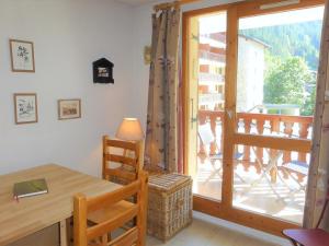 a room with a table and a door to a balcony at Charmant appart rénové 4 pers, balcon sud, plein centre, proche ski et piscine! - FR-1-342-187 in Arêches