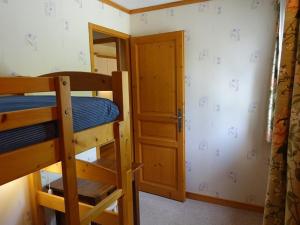 1 dormitorio con 2 literas y puerta en Appartement cosy 4 pers, skis aux pieds, balcon, parking, 2 étoiles - Location dim. à dim. en hiver - FR-1-342-191, en Arêches