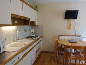 cocina con fregadero y mesa de madera en Appartement cosy 4 pers, skis aux pieds, balcon, parking, 2 étoiles - Location dim. à dim. en hiver - FR-1-342-191, en Arêches