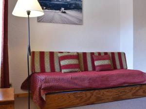 een rode bank met kussens naast een lamp bij Appartement Méribel, 1 pièce, 4 personnes - FR-1-180-385 in Les Allues