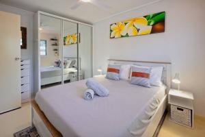 a bedroom with a large white bed with pillows at Entertainer on Martyn in Cairns