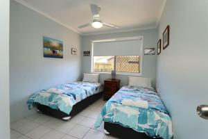 a bedroom with two beds and a window at 46 Holland Street Bargara in Bargara