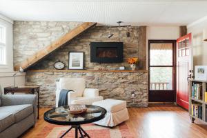 uma sala de estar com uma parede de pedra em Hummingbird House by Country House Escapes em Pine Hill
