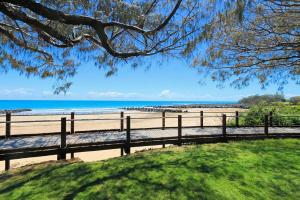 a bench on the beach with the ocean in the background at 41 Miller Street in Bargara