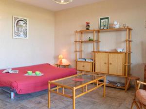 Zimmer mit einem roten Bett und einem Glastisch in der Unterkunft Appartement Le Lavandou, 3 pièces, 5 personnes - FR-1-251-316 in Le Lavandou