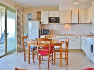 eine Küche mit einem Tisch und Stühlen sowie einem Kühlschrank in der Unterkunft Appartement Le Lavandou, 3 pièces, 5 personnes - FR-1-251-316 in Le Lavandou