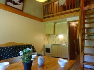 Una cocina con una mesa de madera y una cocina con un sofá. en Appartement 4-5 pers. à Arêches-Beaufort - Pied des Pistes, Balcon Sud, Parking, Casier à Skis - FR-1-342-134, en Arêches