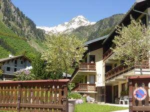un edificio con una valla y una montaña en el fondo en Appartement 4-5 pers. à Arêches-Beaufort - Pied des Pistes, Balcon Sud, Parking, Casier à Skis - FR-1-342-134, en Arêches