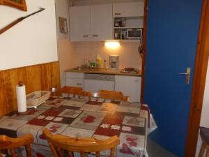 uma cozinha com uma mesa e cadeiras e uma cozinha com uma mesa e uma mesa em Appartement Arêches-Beaufort, 2 pièces, 4 personnes - FR-1-342-139 em Arêches