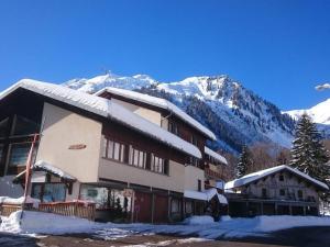 a ski lodge with snow covered mountains in the background at Grand appartement pour 8 personnes, ski au pied, au cœur d'Arêches-Beaufort - FR-1-342-150 in Arêches