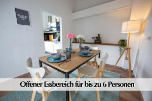 - une salle à manger avec une table et des chaises en bois dans l'établissement 80m2 3R Wohnung mit privatem Parkplatz, Kingsize Betten, Smart-TV, etc, à Erfurt