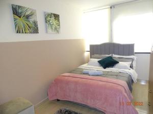 a bedroom with a bed with a pink blanket at Acogedor apartamento en Fusagasugá in Fusagasuga