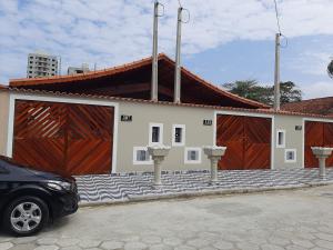 un coche aparcado frente a un edificio con dos puertas en Bela Mar Mongaguá, en Mongaguá