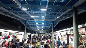 una multitud de personas caminando por un mercado en Bela Mar Mongaguá, en Mongaguá