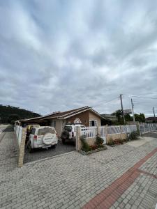 una casa con dos coches aparcados en una entrada en Casa de Temporada Familiar, en Urubici