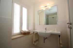 a white bathroom with a sink and a window at Affittacamere le Tre Sorelle in Sirolo