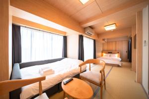 Habitación con cama, escritorio y silla. en WELLSTAY Shinsekai Wakyo, en Osaka