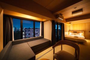 Una pequeña habitación con una cama y una ventana. en WELLSTAY Shinsekai Wakyo, en Osaka