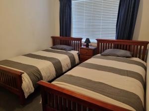 two beds in a room with a window at Busselton Broadwater Holiday Home in Busselton