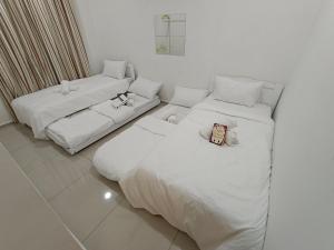 um quarto com duas camas e um sofá em KLIA EHSAN Residence Sepang Nilai Greenery 8 PAX Air-Con Suite em Sepang