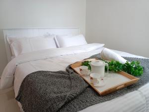 uma bandeja com duas canecas e duas chávenas numa cama em KLIA EHSAN Residence Sepang Nilai Greenery 8 PAX Air-Con Suite em Sepang