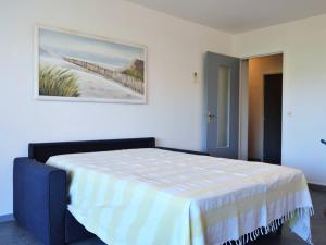 a bedroom with a bed with a painting on the wall at Appartement Le Lavandou, 2 pièces, 4 personnes - FR-1-251-297 in Le Lavandou