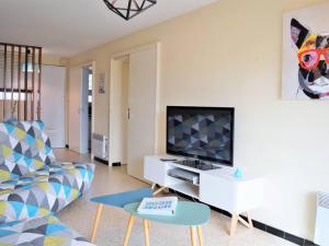 uma sala de estar com um sofá e uma televisão em Appartement Le Lavandou, 2 pièces, 4 personnes - FR-1-251-295 em Le Lavandou