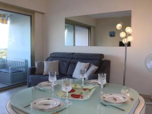 a living room with a table with plates and wine glasses at Appartement Villeneuve-Loubet, 2 pièces, 4 personnes - FR-1-252A-9 in Villeneuve-Loubet